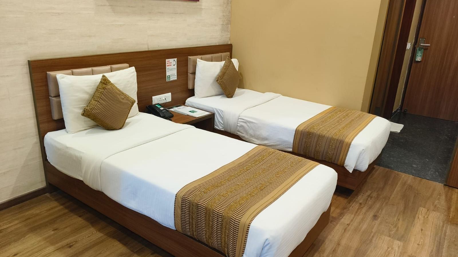 A side corner angle view of the room with twin beds, a wall frame, at Le ROI Digha Hotel, West Bengal.